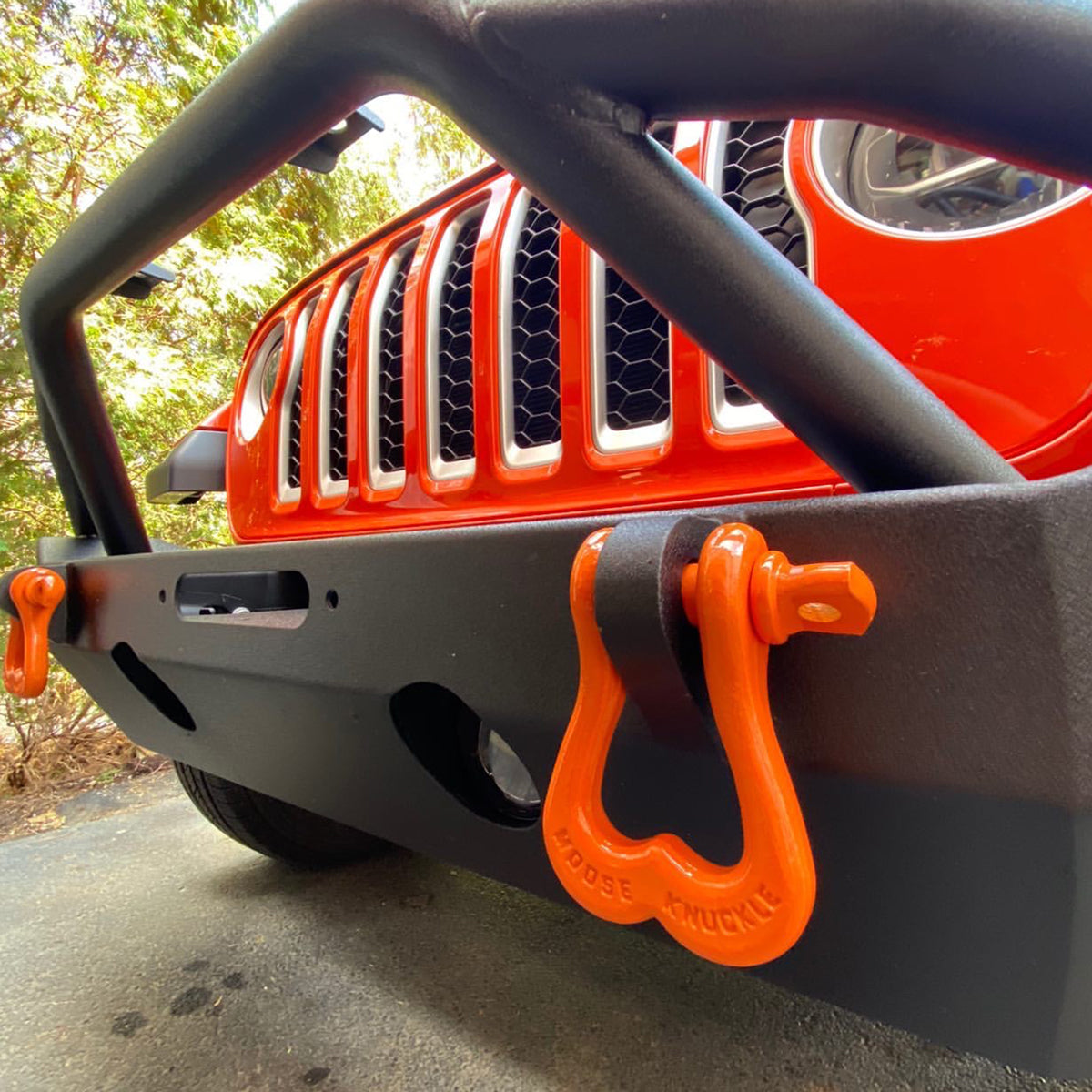 Orange D-Ring Shackles on the front bumper of a Jeep Wrangler